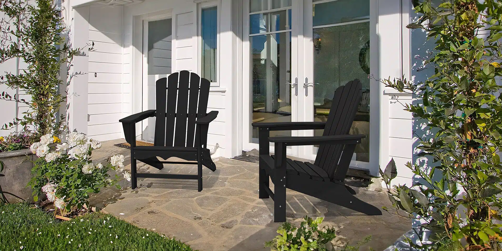 Two outdoor poly adirondack chairs on the porch