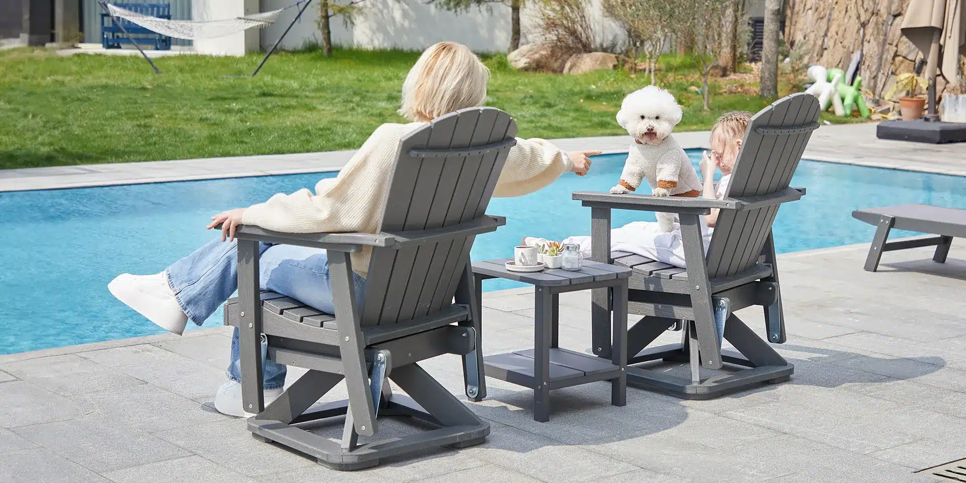 A mon and her daughter resting on th glider adirondack chair by the pool side