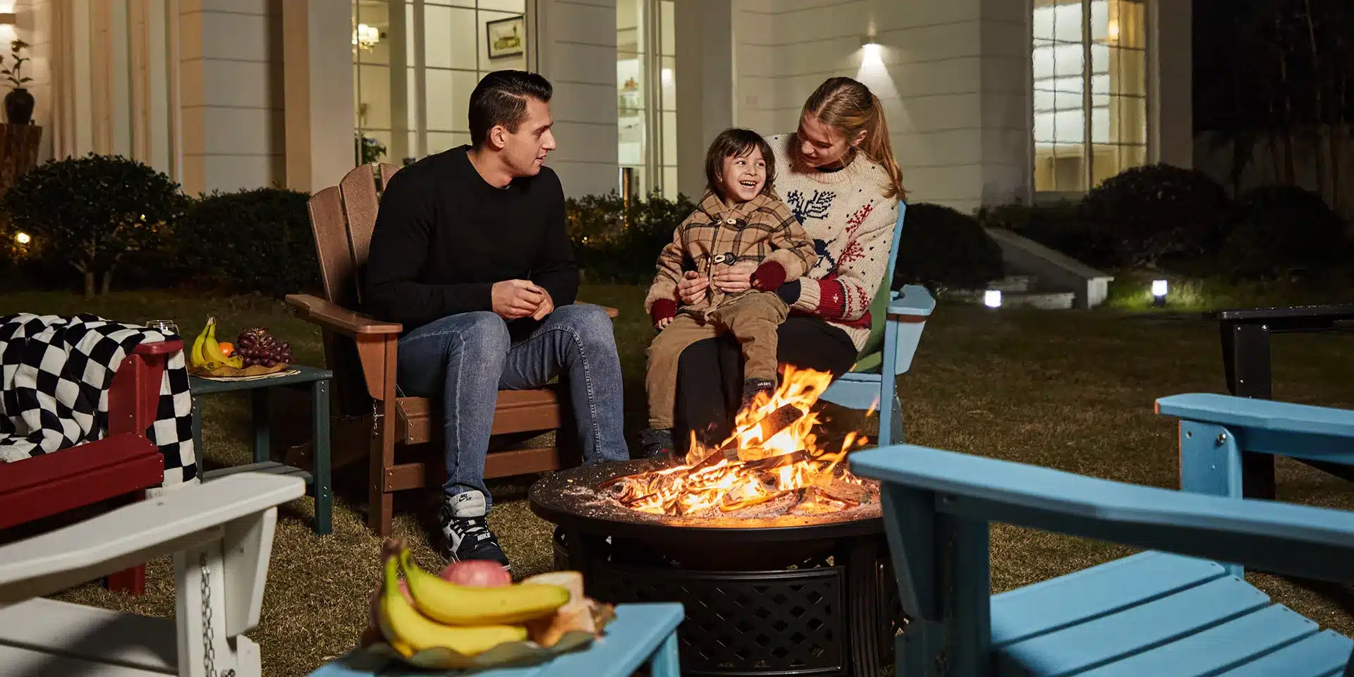 family sit around the fire pit