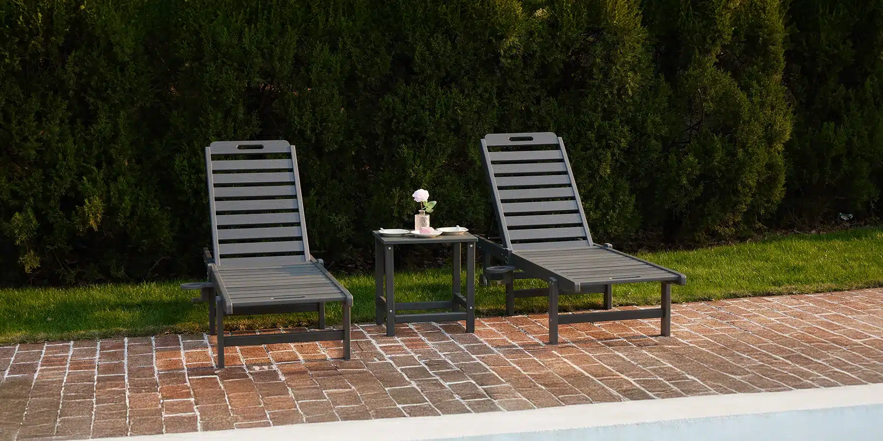 Two Gray Outdoor Lounge Chairs with Reclining Backrest by the Pool